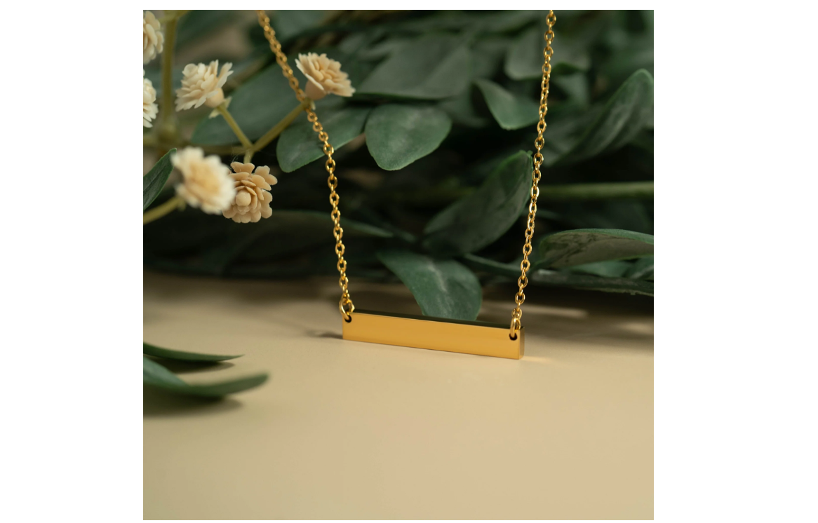 Gold necklace with a bar pendant. 