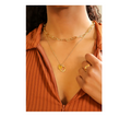 Gold necklace with a heart pendant worn by a model.